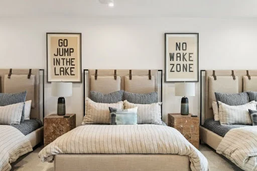A room made for sleeping in, waking up slowly, and heading straight for the lake.
Layered textures, playful artwork, and thoughtful details give this shared space plenty of personality without losing that calm, collected feel.

@fourhandsfurniture 
@wendoverart 
@pompomathome 
@harborviewcustombuilders 
@uttermostcompany